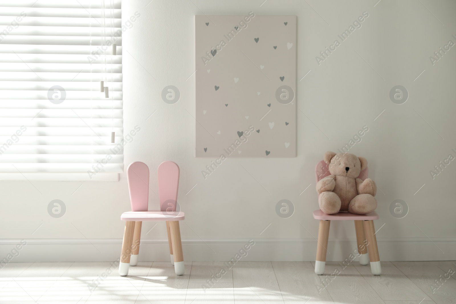 Photo of Cute chairs with bunny ears in children's room interior