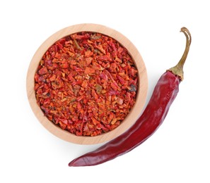 Photo of Aromatic spice. Red chili pepper flakes in bowl and pod isolated on white, top view