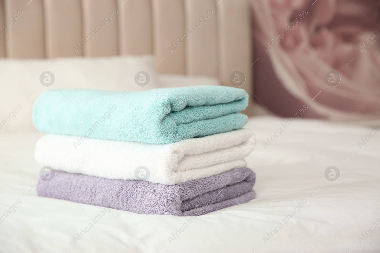 Photo of Soft clean towels on bed at home