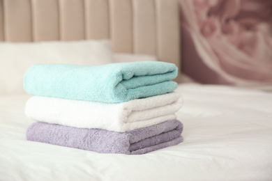 Soft clean towels on bed at home