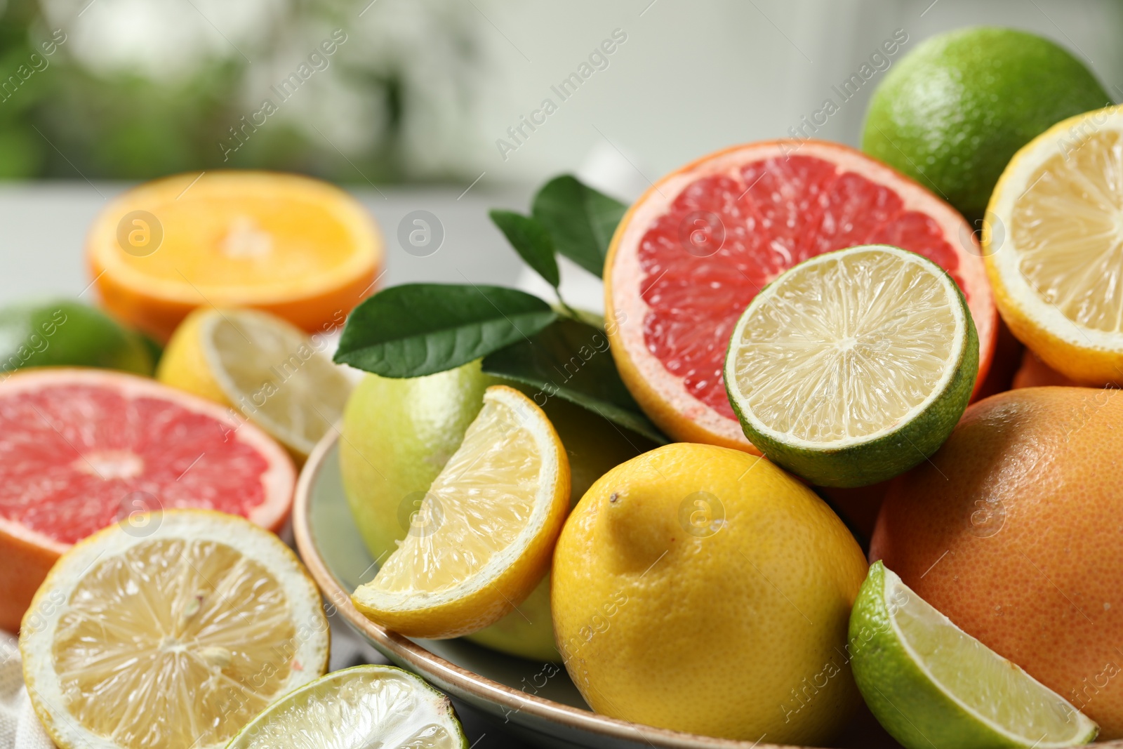 Photo of Different fresh citrus fruits on table, closeup