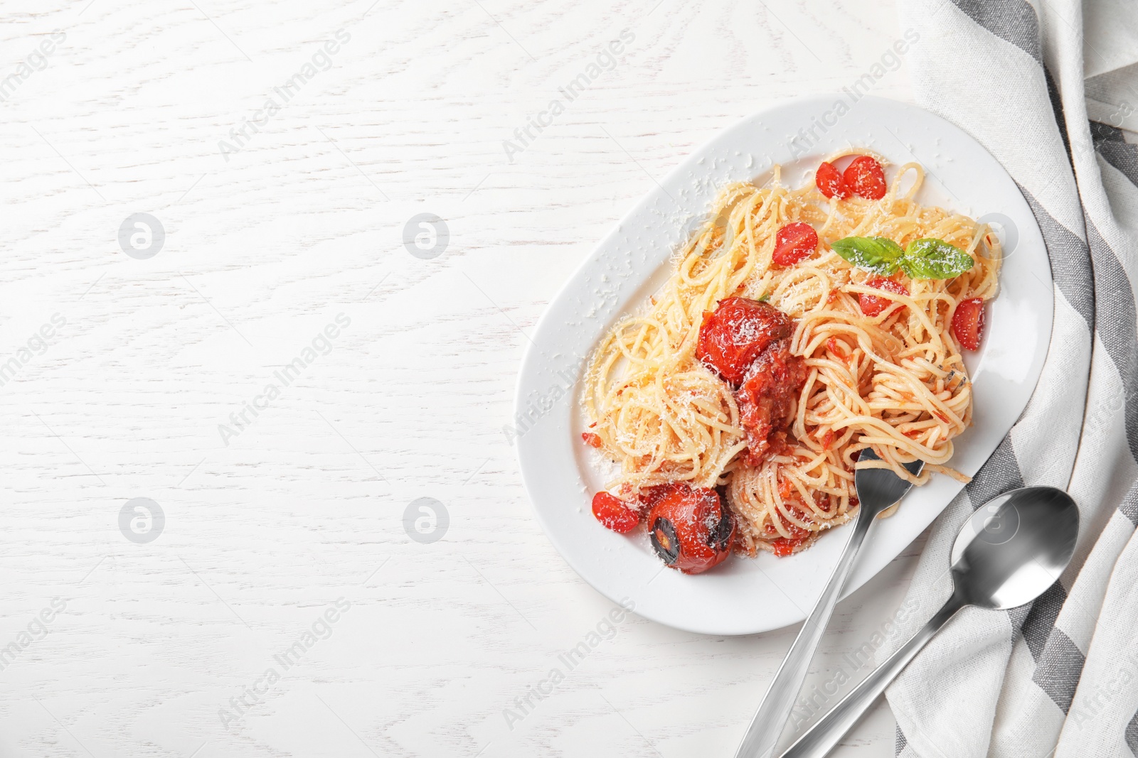 Photo of Tasty pasta and napkin on white wooden table, flat lay. Space for text