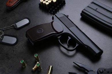 Composition with professional gun on black background, above view