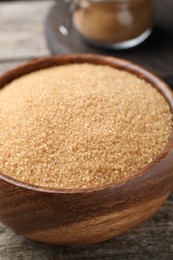Photo of Brown sugar in bowl on wooden table, closeup