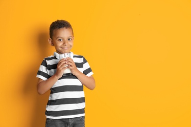 Photo of Adorable African-American boy with glass of milk on color background