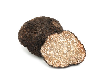 Photo of Cut and whole black truffles isolated on white