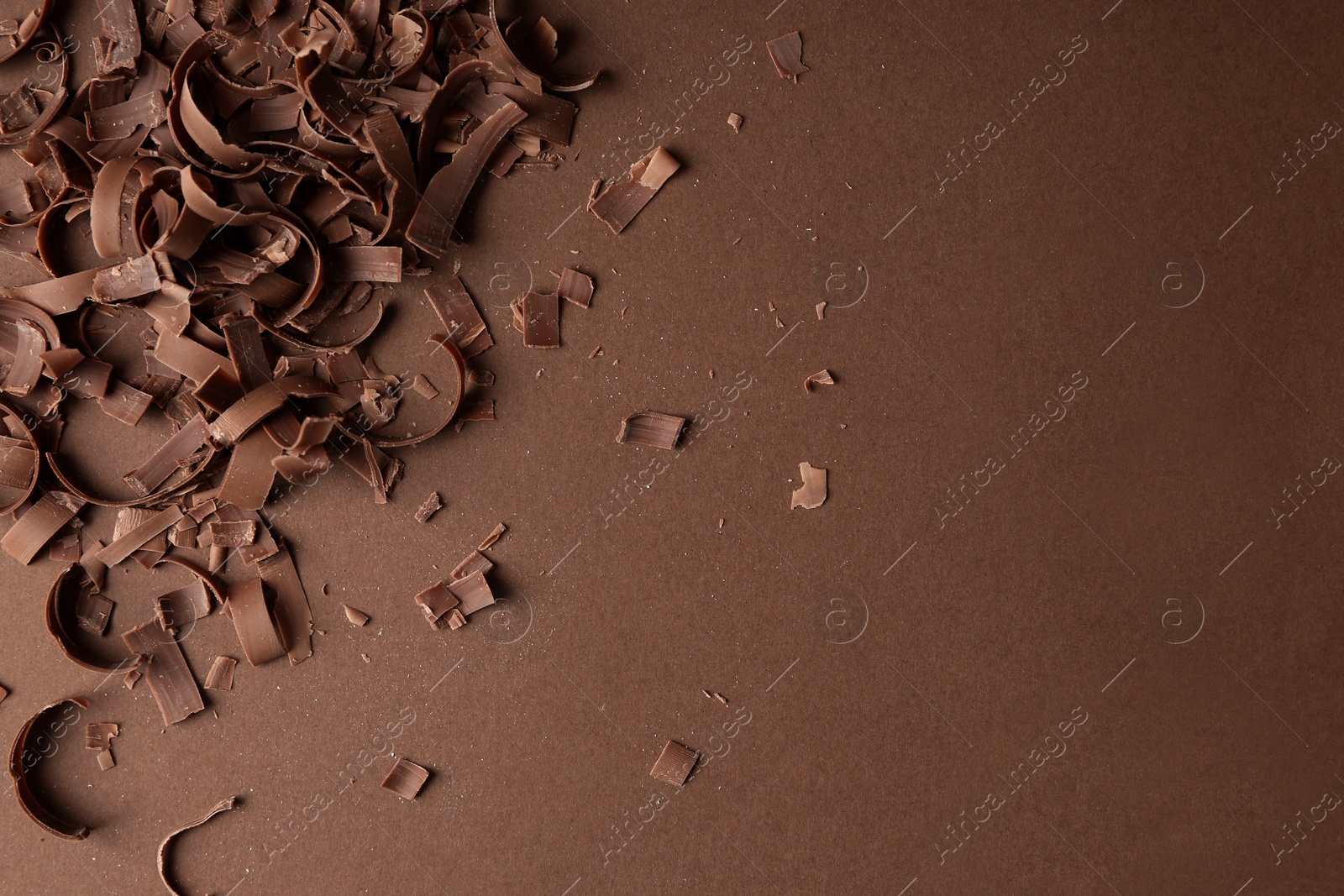 Photo of Chocolate curls and space for text on color background, top view