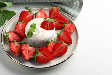 Delicious strawberries with whipped cream on white table, space for text