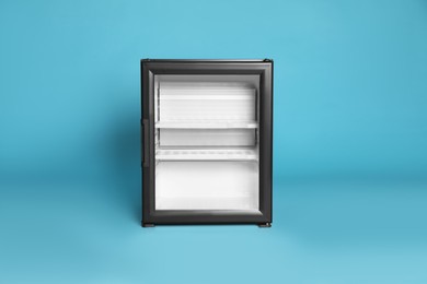 Empty mini bar with glass door on turquoise background