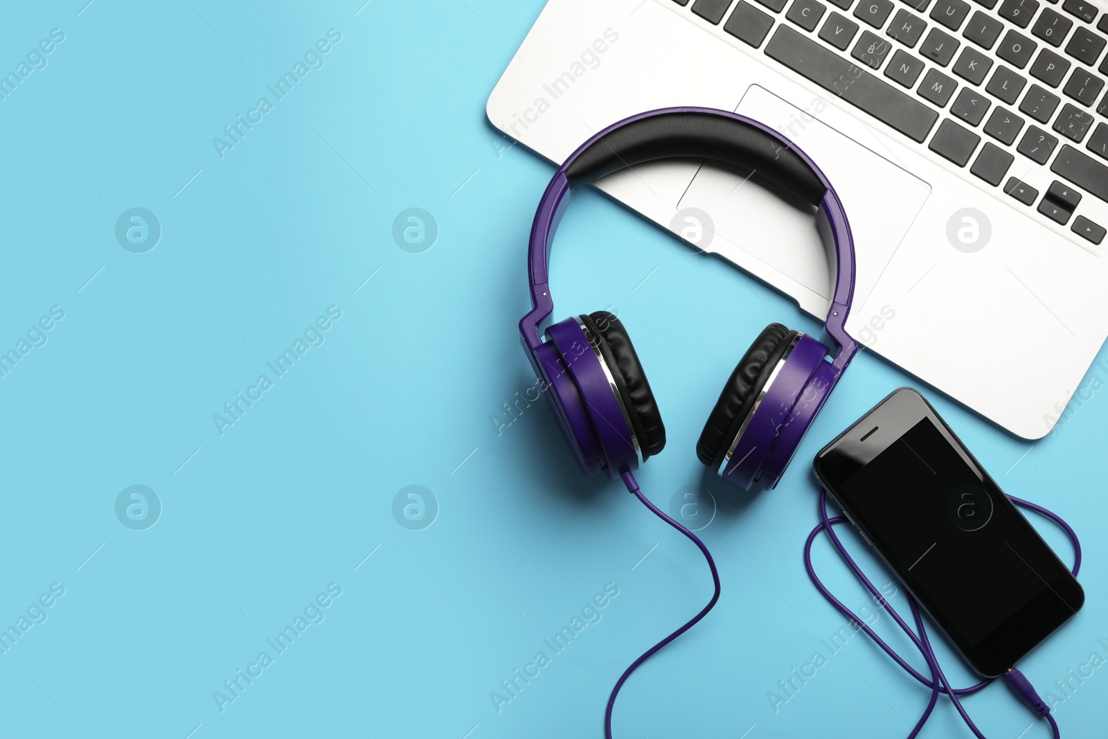 Photo of Modern headphones, phone and laptop on color background, flat lay. Space for text