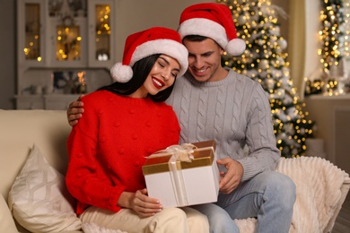 Happy couple with Christmas gift box at home