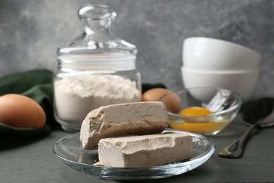 Compressed yeast, eggs and flour on grey table