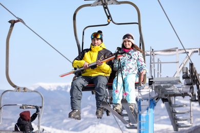 People using chairlift at mountain ski resort. Winter vacation