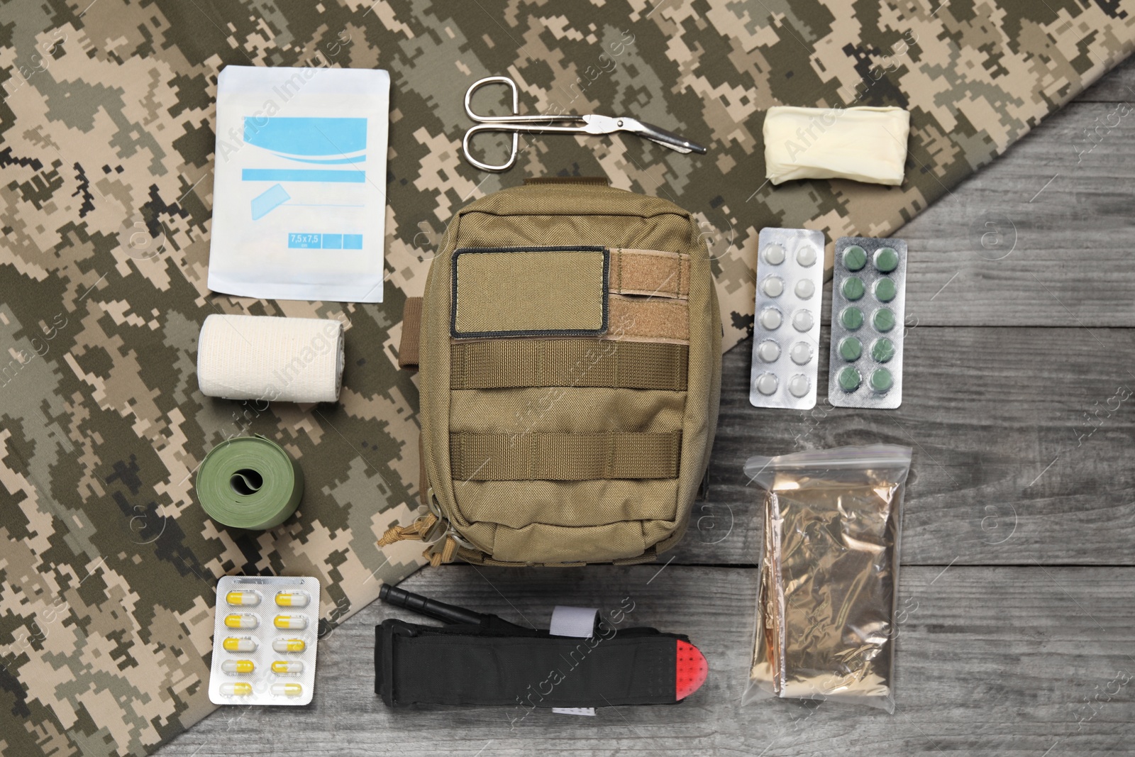 Photo of Flat lay composition with military first aid kit on wooden table