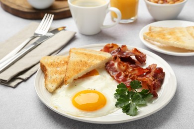 Delicious breakfast with sunny side up egg served on light table, closeup