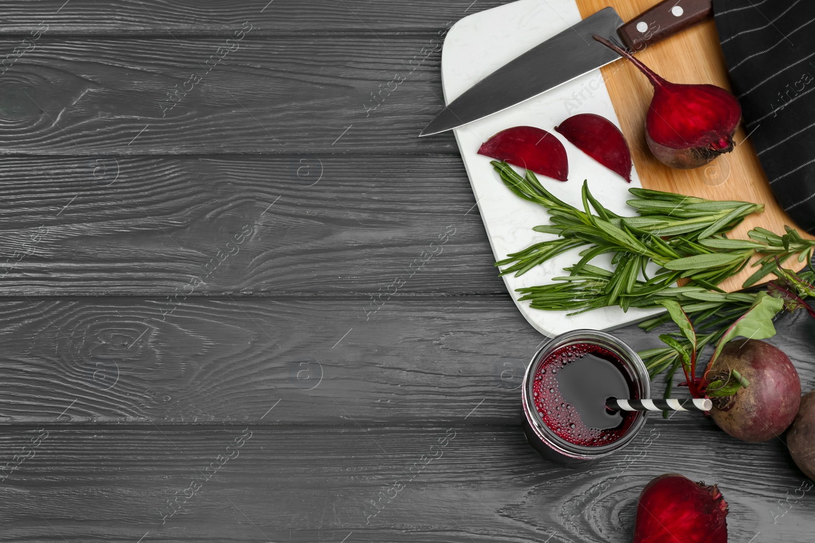 Photo of Fresh beet juice and raw vegetable on grey wooden table, flat lay. Space for text