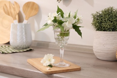 Photo of Beautiful jasmine flowers on wooden table indoors