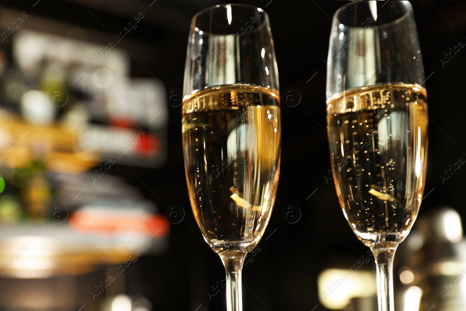 Photo of Glasses of champagne in bar, low angle view. Space for text