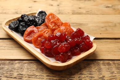 Different delicious dried fruits on wooden table