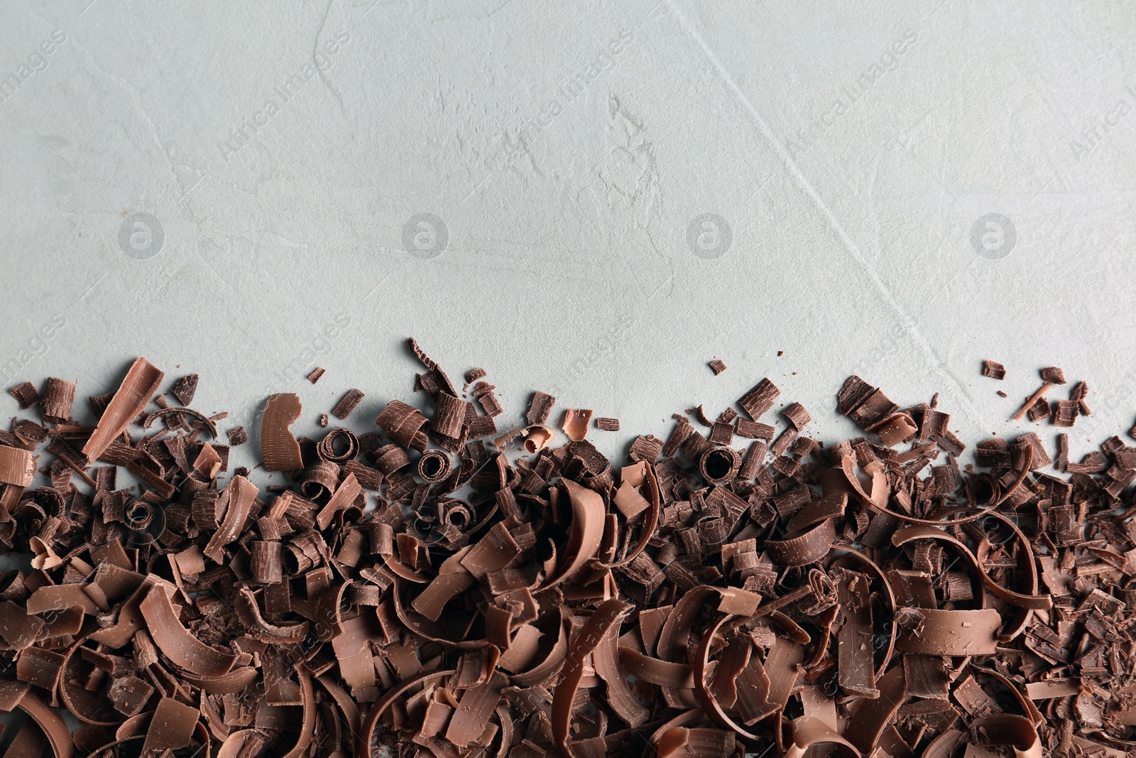 Photo of Chocolate curls and space for text on gray background, top view