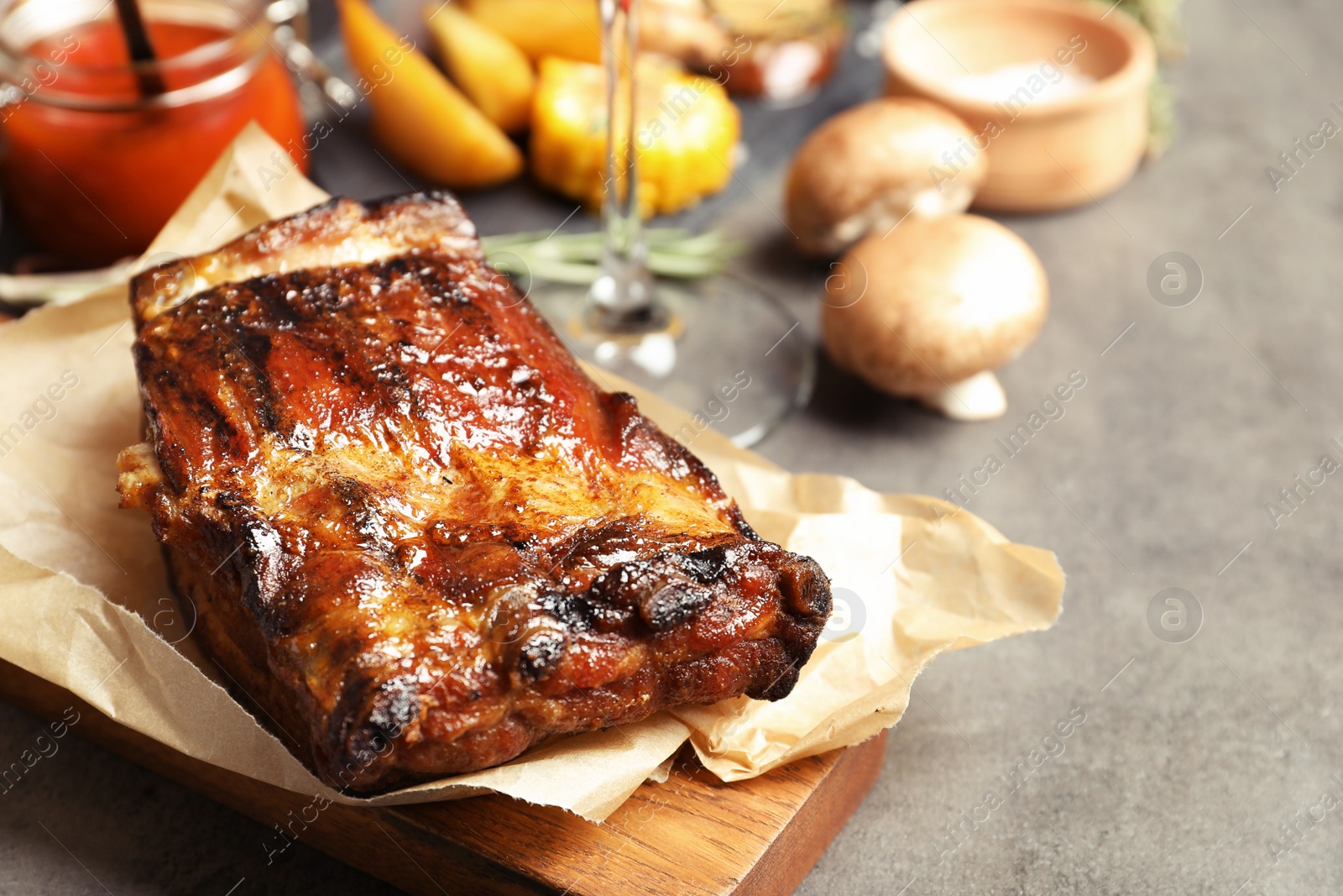 Photo of Piece of delicious barbecued ribs served on gray table