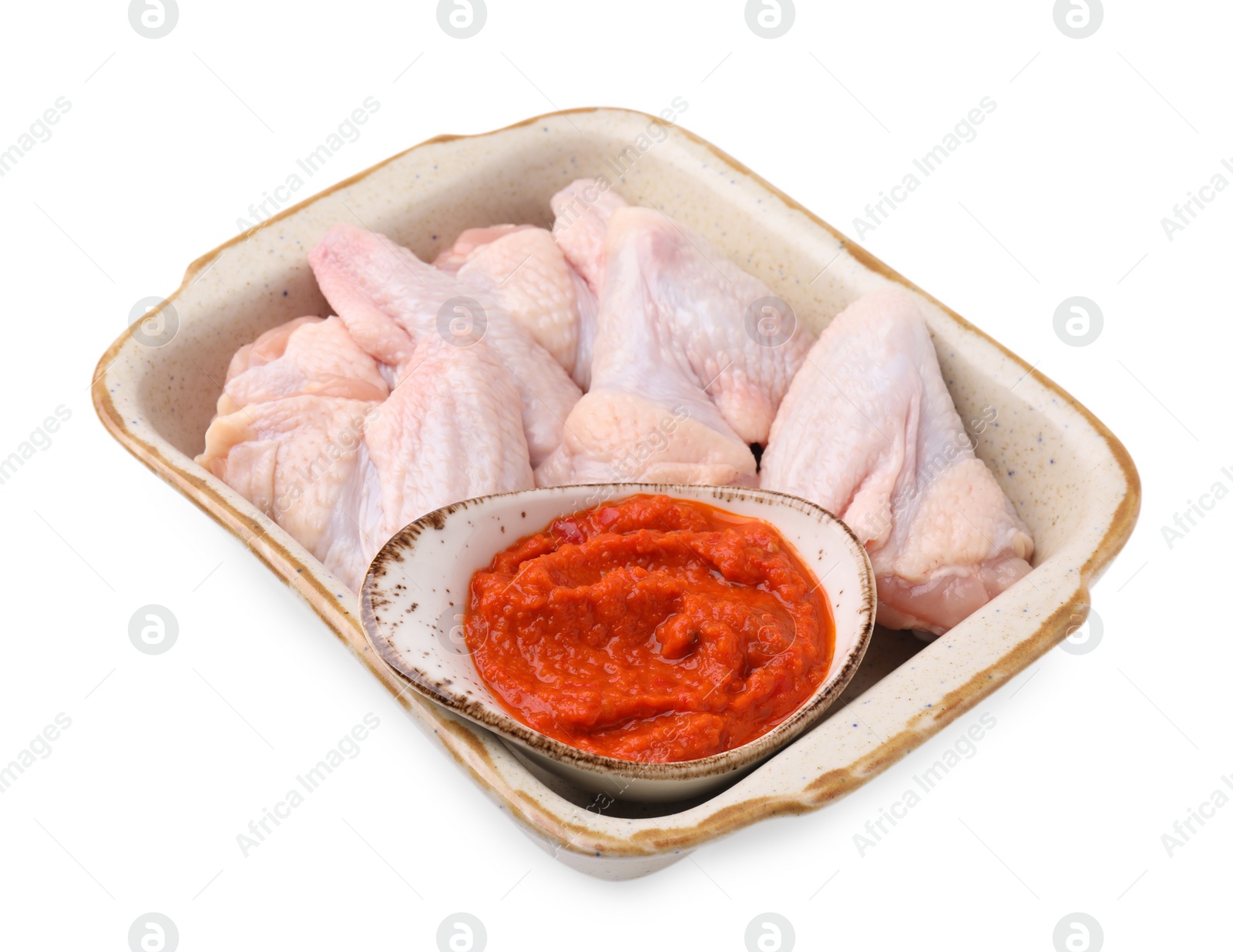 Photo of Fresh marinade and raw chicken in baking dish isolated on white
