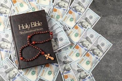 Photo of Holy Bible, cross and money on grey table, top view