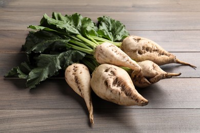 Photo of Fresh sugar beets with leaves on wooden table