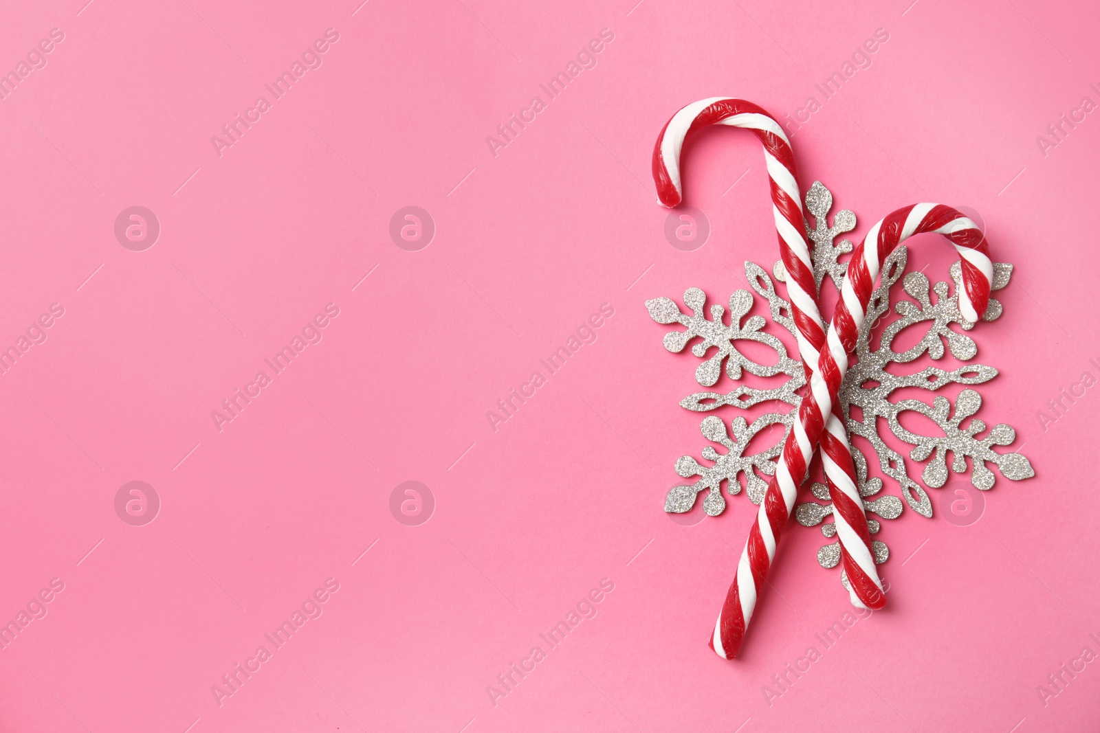 Photo of Flat lay composition with tasty candy canes and space for text on color background
