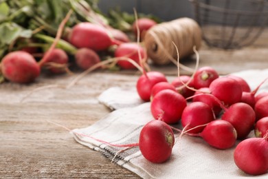 Photo of Fresh red ripe radishes on wooden table, space for text