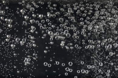 Photo of Clear soda water on black background, closeup