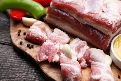 Photo of Pieces of pork fatback on wooden table, closeup