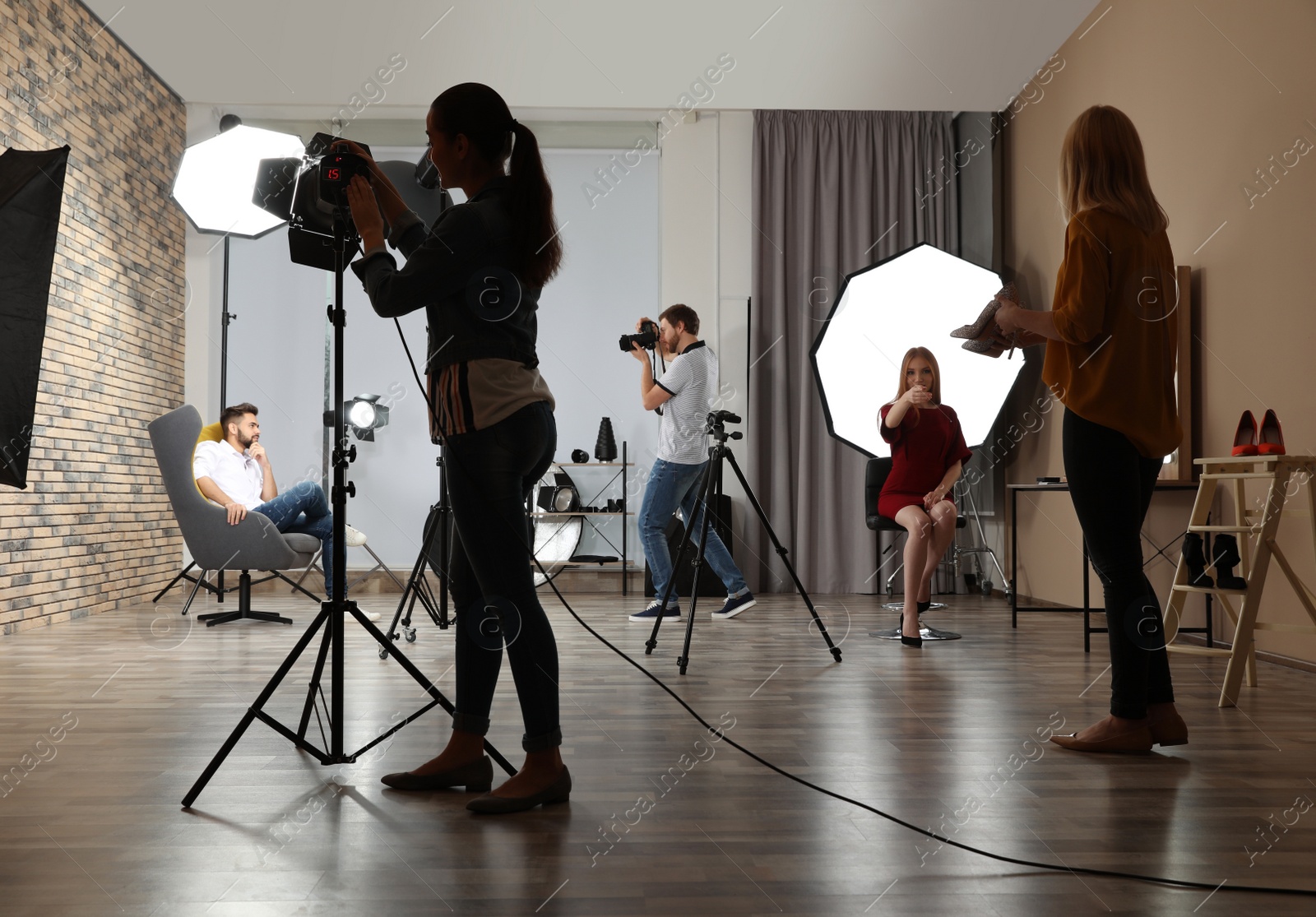 Photo of Photo studio with professional equipment and team of workers