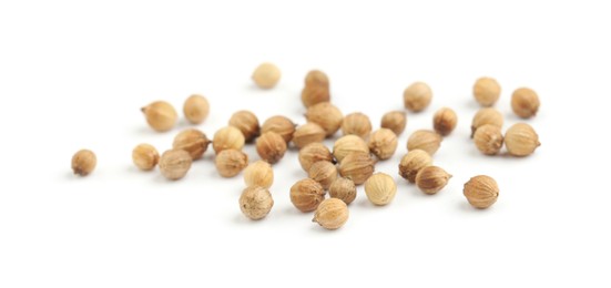 Photo of Scattered dried coriander seeds on white background