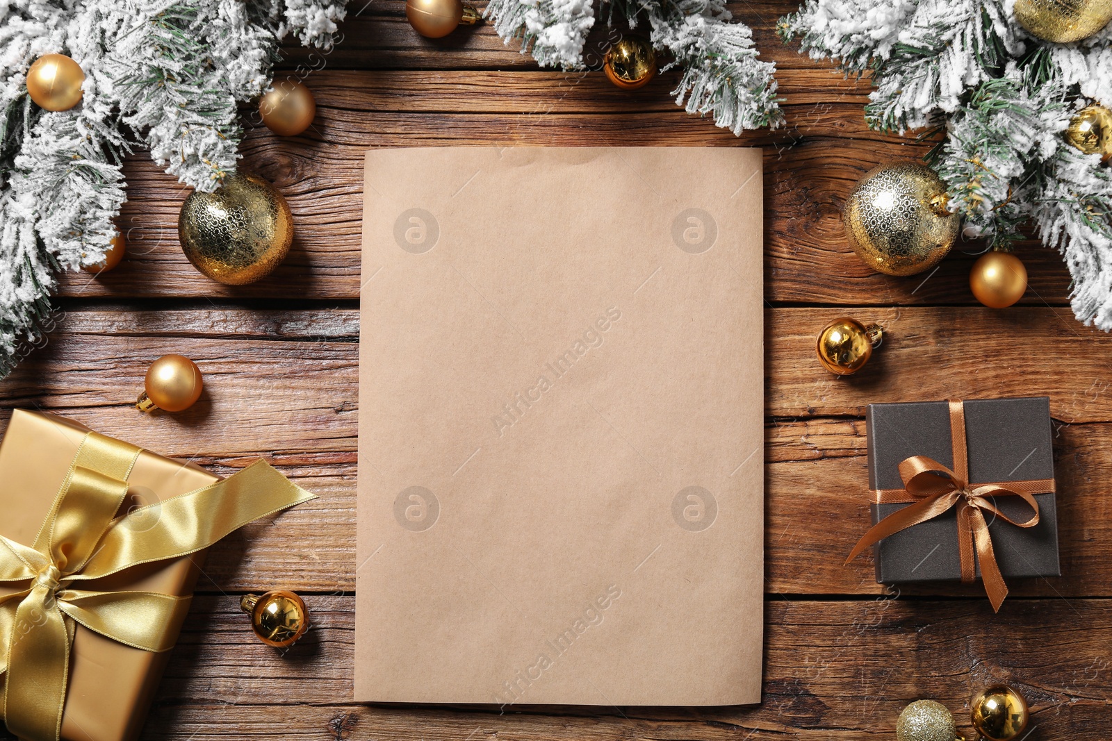 Photo of Flat lay composition with blank paper sheet and Christmas decor on wooden table, space for text. Letter for Santa