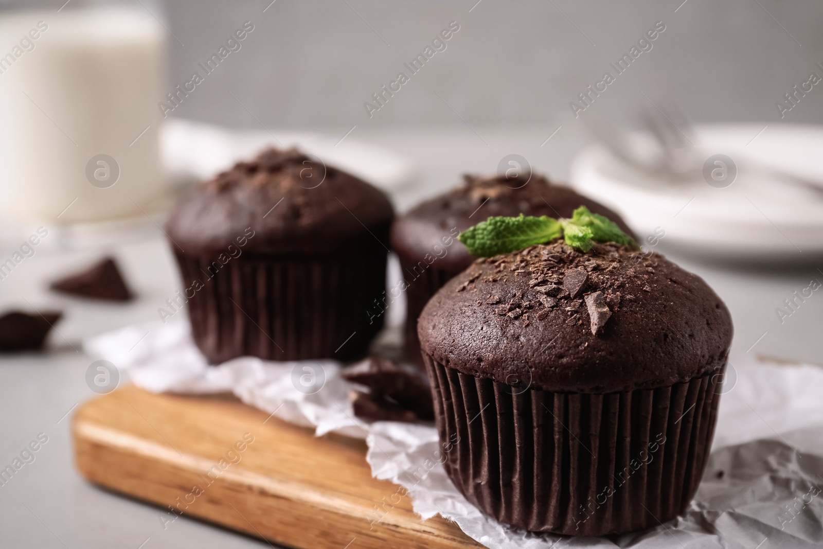 Photo of Delicious chocolate muffins served on grey table, closeup. Space for text