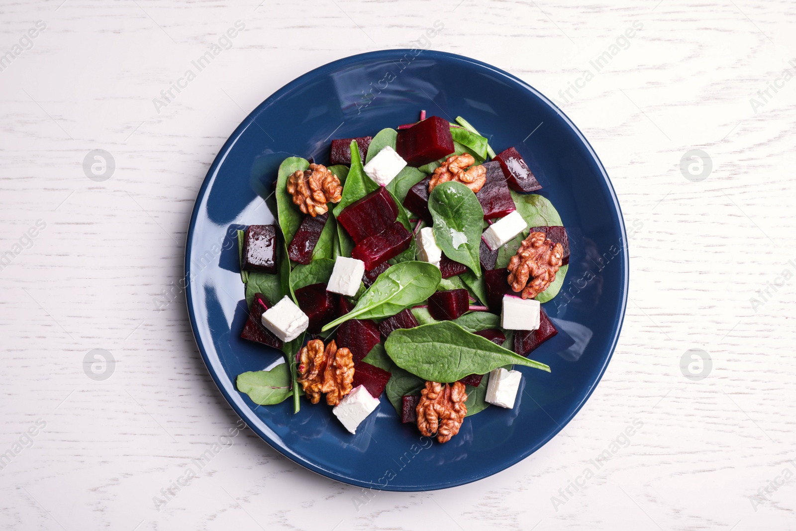Photo of Fresh delicious beet salad on white wooden table, top view