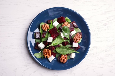 Fresh delicious beet salad on white wooden table, top view