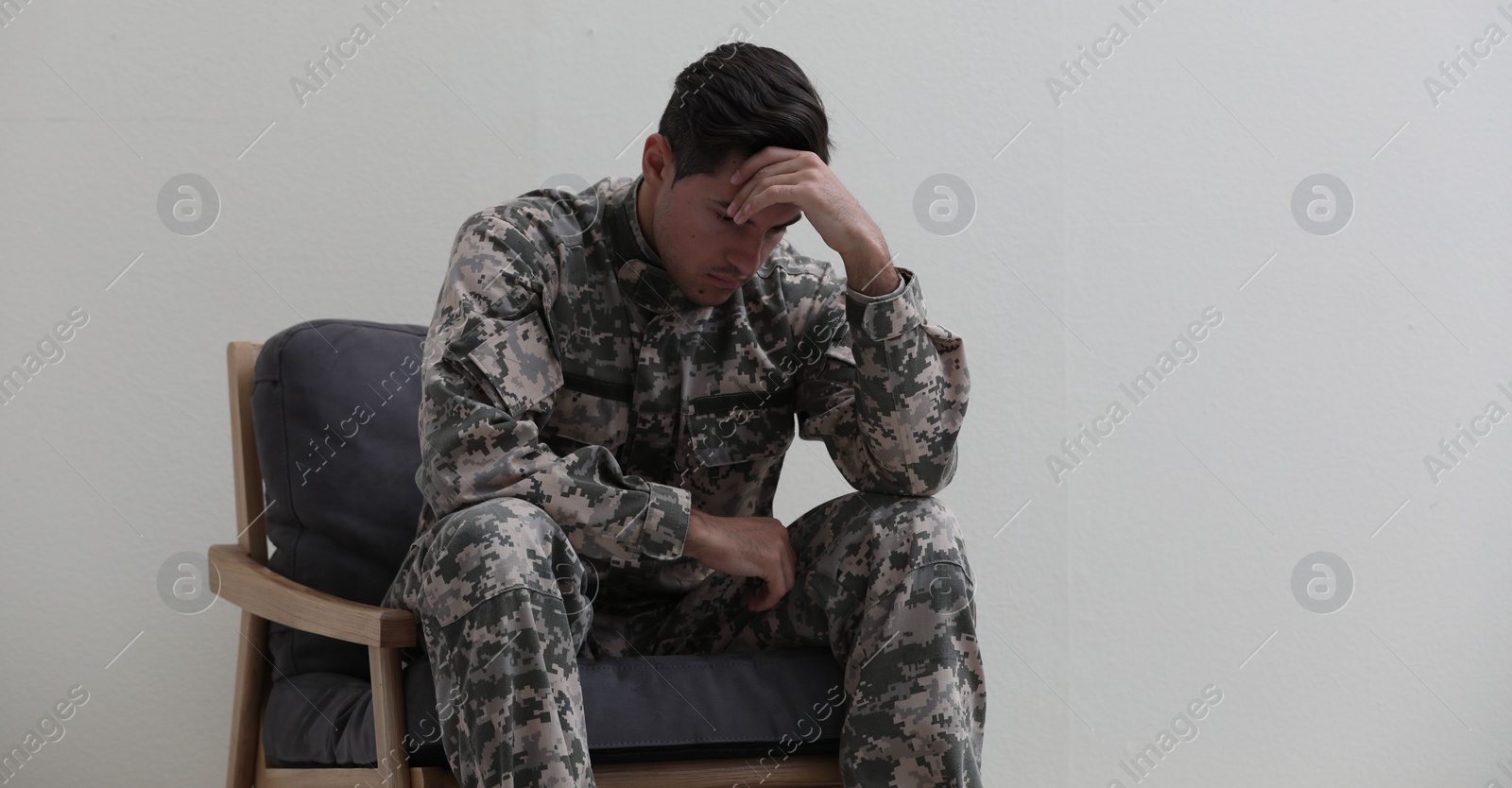 Photo of Stressed military officer sitting in armchair on white background