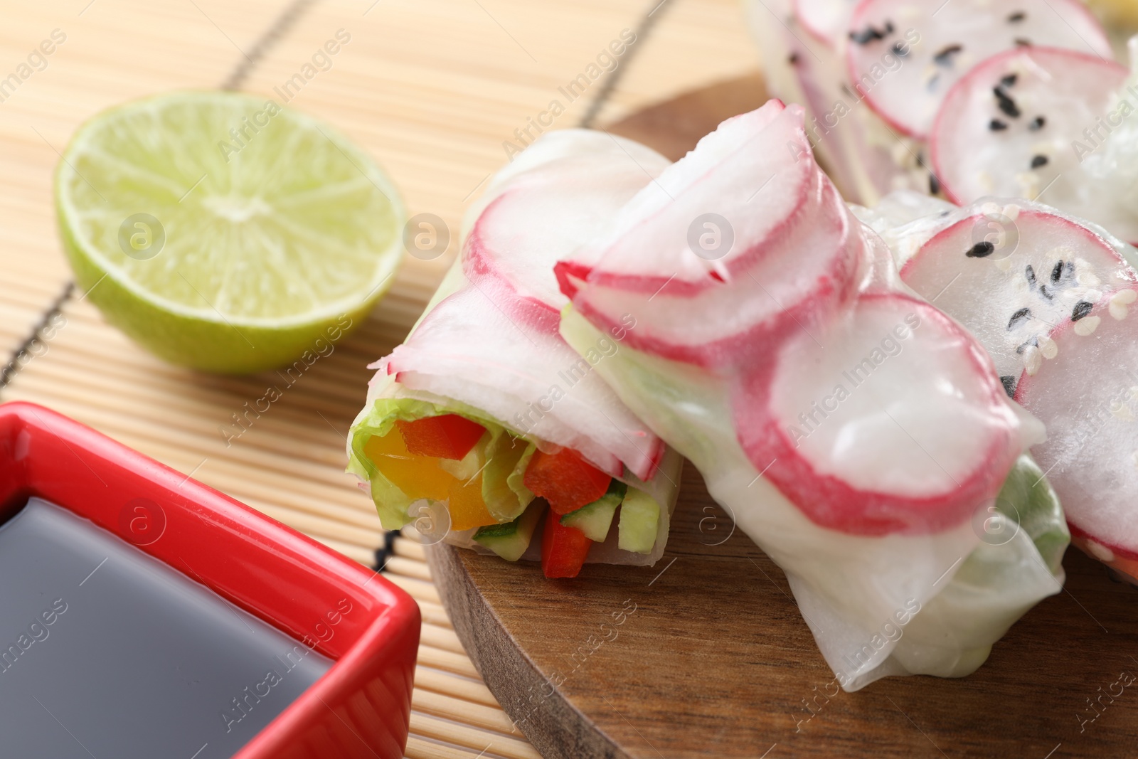 Photo of Delicious spring rolls, lime and soy sauce on table, closeup