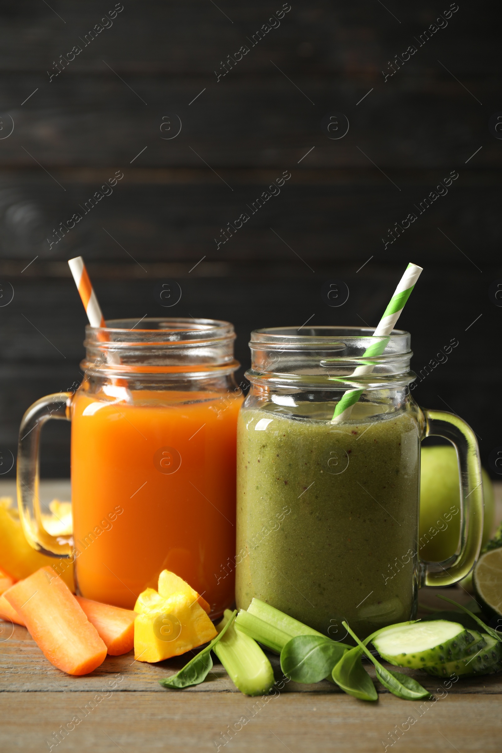 Photo of Delicious vegetable juices and fresh ingredients on wooden table