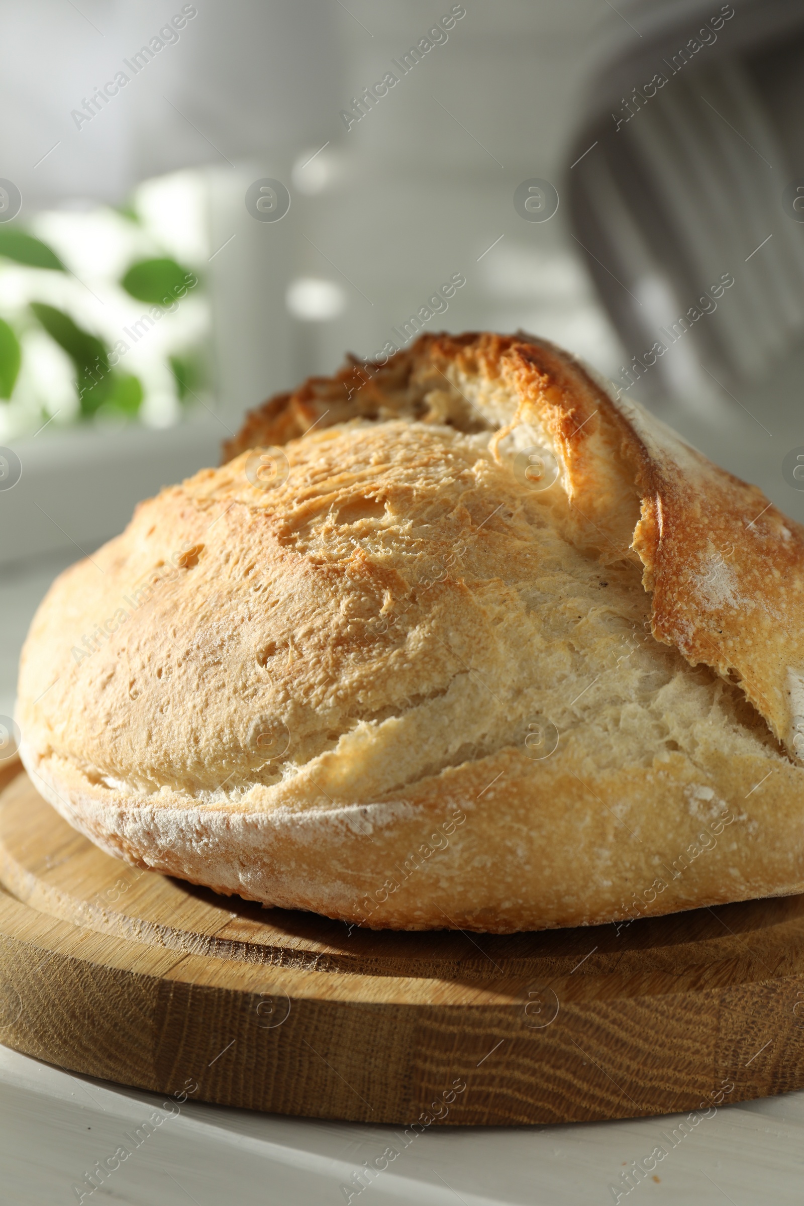 Photo of Freshly baked sourdough bread on white wooden table indoors