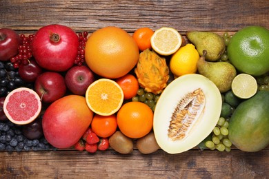 Photo of Many different fresh fruits and berries on wooden table, flat lay