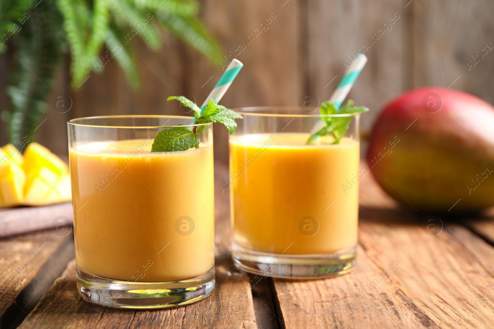 Photo of Fresh delicious mango drink on wooden table