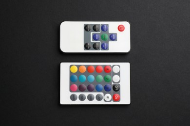 Photo of Remote controls on black background, flat lay