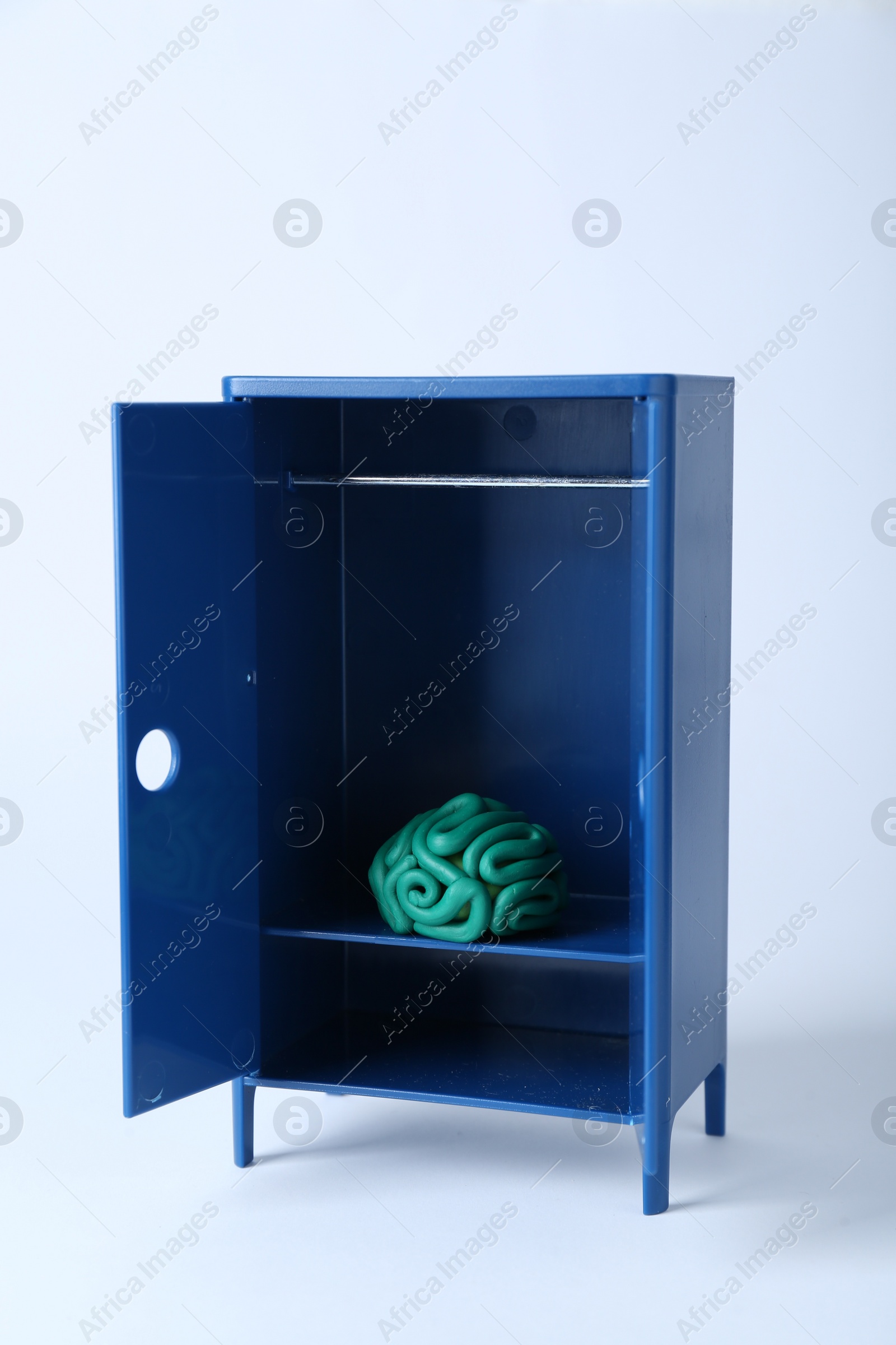 Photo of Brain made of plasticine in mini wardrobe against white background