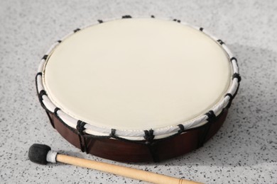 Photo of Drum and drumstick on grey table, closeup. Percussion musical instrument