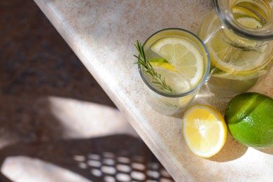 Photo of Tasty refreshing lemonade and ingredients on light table, above view. Space for text