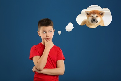 Little boy dreaming about cute puppy, blue background