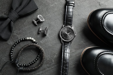 Flat lay composition with luxury wrist watch on black background